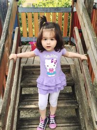 Portrait of cute girl standing on wood