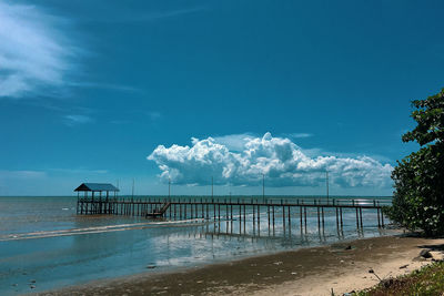 Pier on beach against sky 
