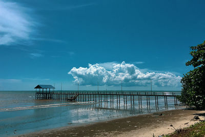 Pier on beach against sky