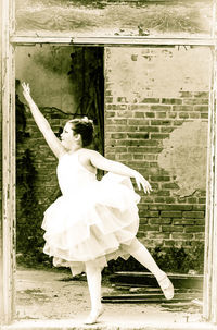 Low angle view of woman standing by wall