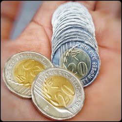 Close-up of hand holding coins