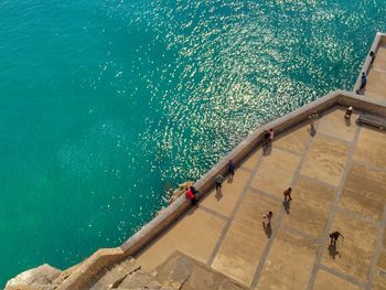 High angle view of people on building terrace by sea