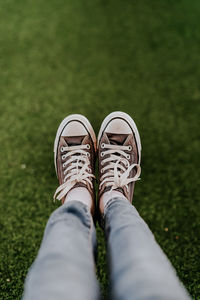 Low section of person wearing shoes on grass