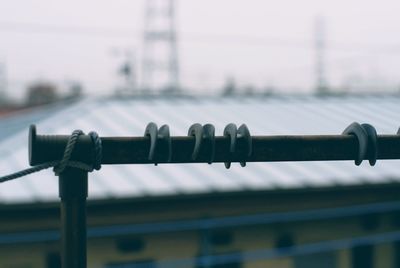 Close-up of metal railing against sky