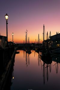 Silhouette boats in lake against sky during sunset