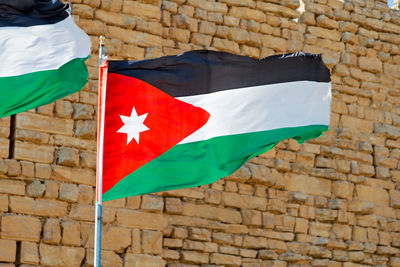 Low angle view of flag against brick wall