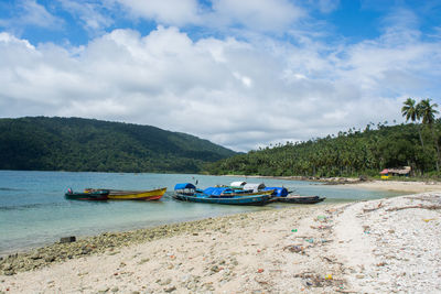 Boats moored on sea against sky