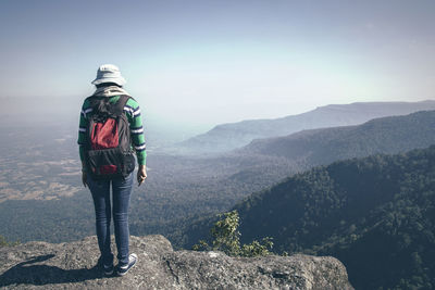 Rear view full length of woman standing on mountain against sky