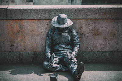 Midsection of person sitting against wall