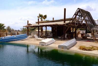 Built structure by river against sky