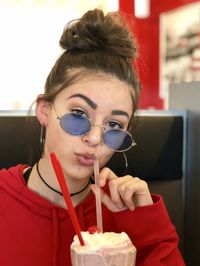 Portrait of teenage girl drinking iced coffee in cafe