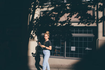 Full length of young woman using mobile phone