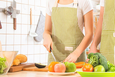 Midsection of woman preparing food in kitchen