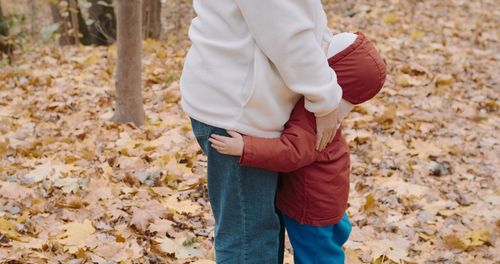 Midsection of woman standing on field during autumn