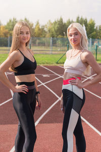 Portrait of happy friends standing on field