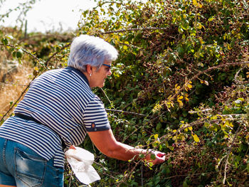 Senior woman gardening on field