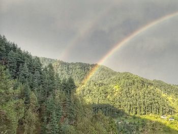 Scenic view of rainbow over mountain against sky