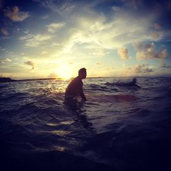 Silhouette man on beach against sky during sunset