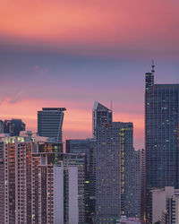 Modern buildings against sky during sunset