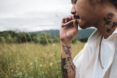 Side view of man smoking marijuana joint