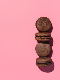 Close-up of stack on table against pink background