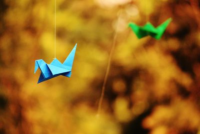 Close-up of origami birds hanging in yard