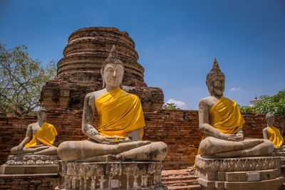 Buddha statue against temple against sky