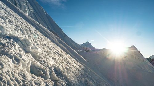 Scenic view of snowcapped mountains against sky on sunny day