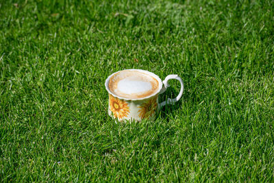 Close-up of coffee cup on grass