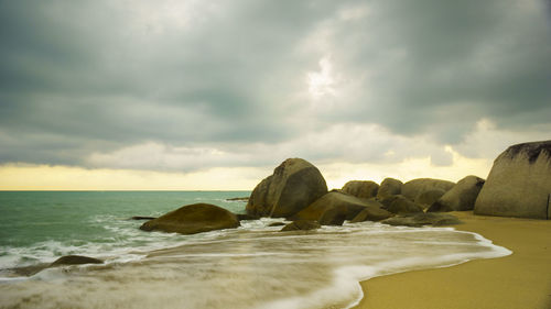 Rocks on beach against sky