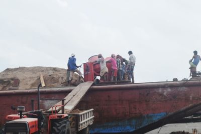 Low angle view of people on car against sky