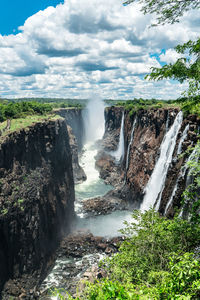 Scenic view of waterfall against sky