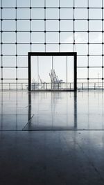 Cranes at port of hamburg seen from building glass