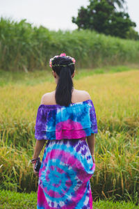 Rear view of young woman standing on field