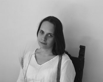 Portrait of young woman against wall