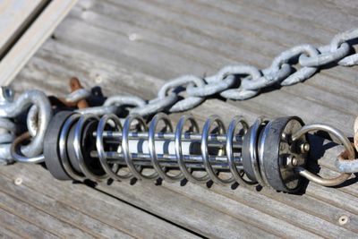 High angle view of metallic equipment and chain on boardwalk