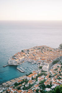 High angle view of townscape by sea against clear sky