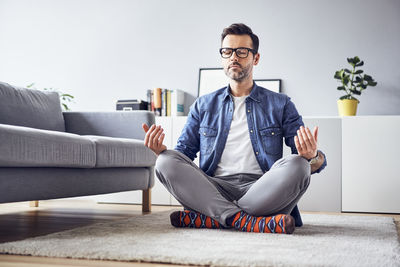 Relaxed man meditating at home