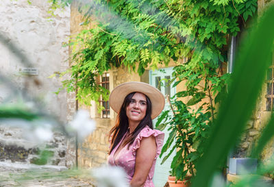 Elegant young woman in pink dress, old town, smile, happy, hat, one person.