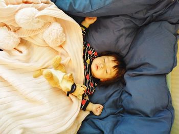 Directly above shot of girl sleeping on bed