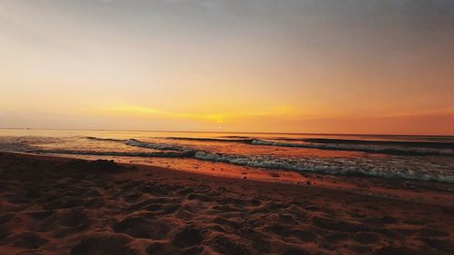 Scenic view of beach against sky during sunset