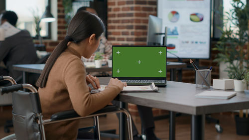 Young woman using laptop at cafe