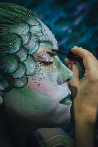 Close-up side view of thoughtful woman with painted face 