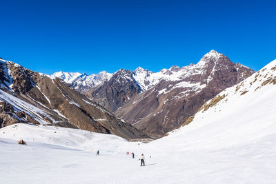 Scenic view of snowcapped mountains against clear blue sky