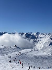 People on snowcapped mountains against sky