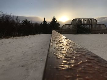 Surface level of railroad tracks against sky during sunset