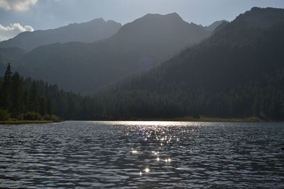 Scenic view of lake by mountains against sky