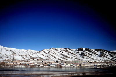 Scenic view of snowcapped mountains against clear blue sky