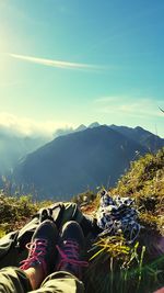 Low section of person in mountains against sky