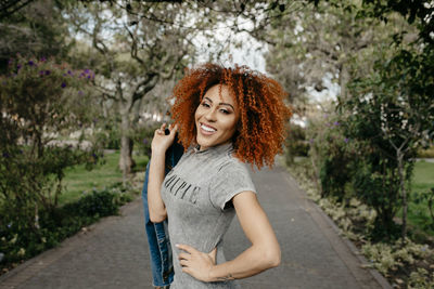 Portrait of smiling young woman against plants